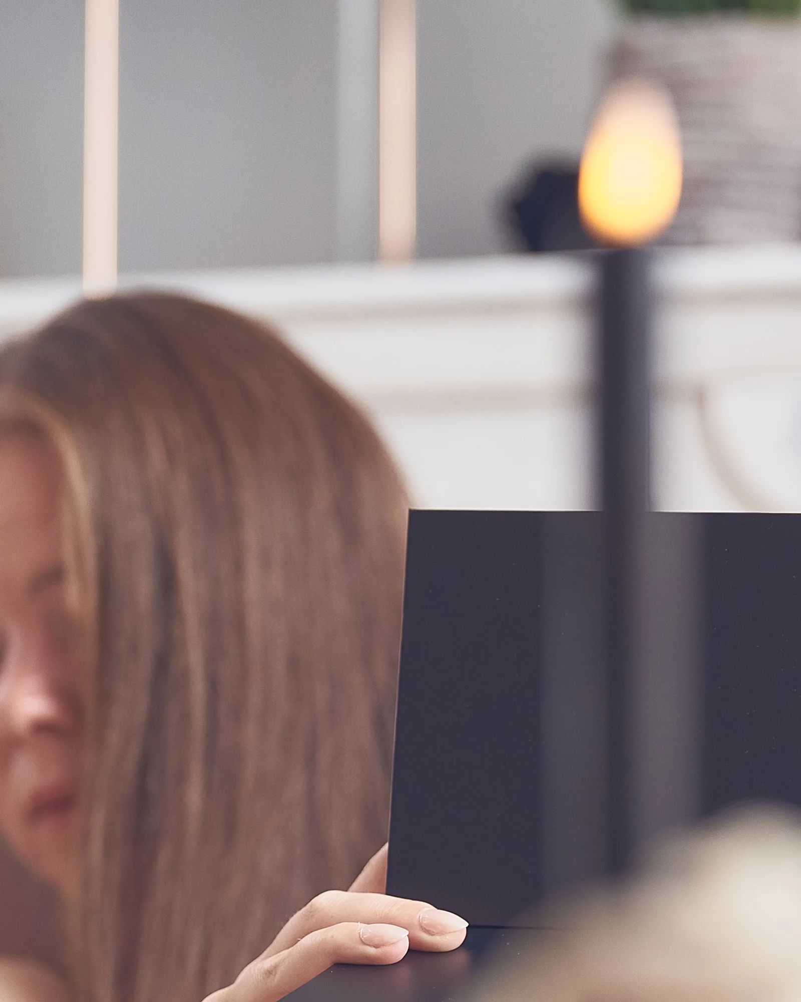 Schwarze Box, im Vordergrund unscharf Haare und eine Hand